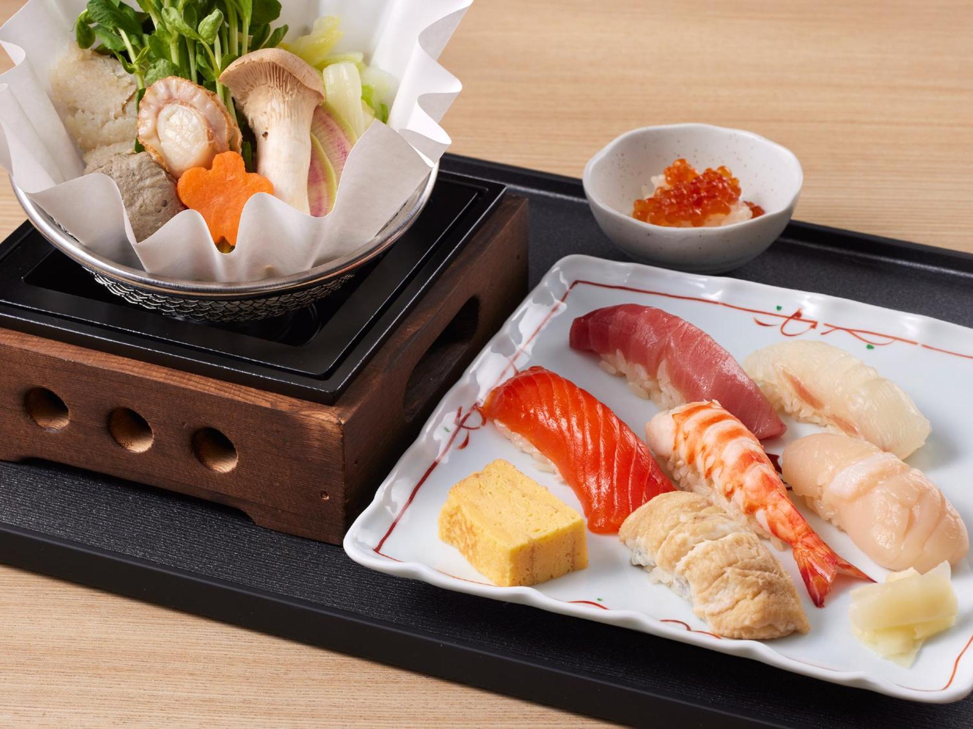 Grand Nikko Tokyo Bay Maihama Hotel Urayasu Ngoại thất bức ảnh The photo features a Japanese meal presented on a wooden tray. On the left, there is a small pot with a clear broth containing vegetables, mushrooms, and possibly meat, indicated by green herbs and a piece shaped like a flower. On the right, there is